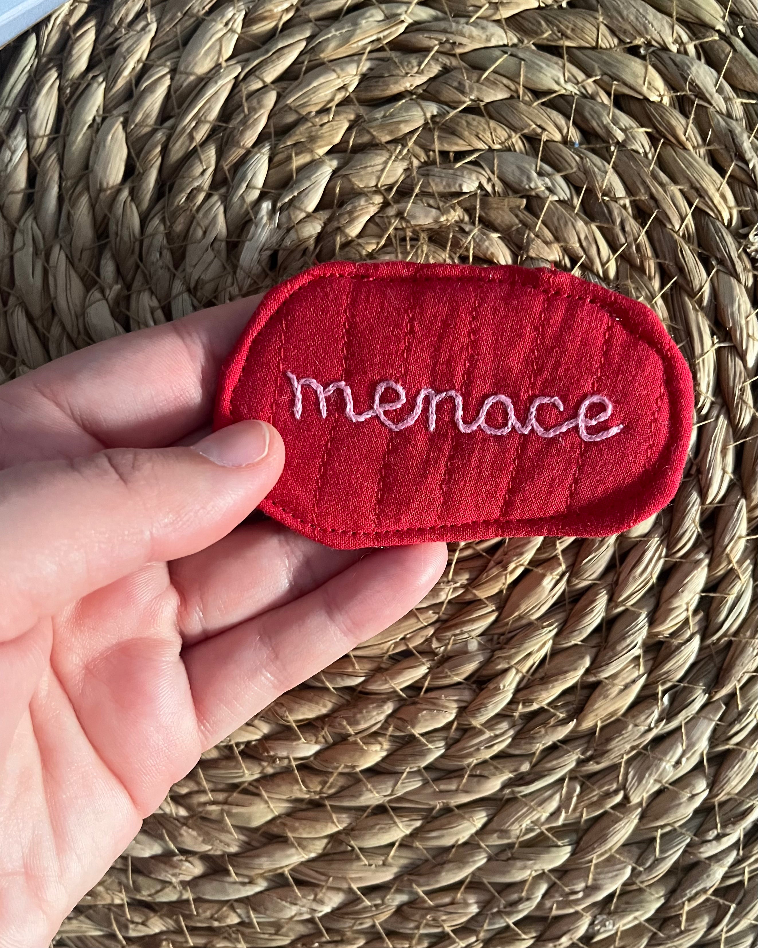 Hand-embroidered "menace" pin, quilted fabric offcut