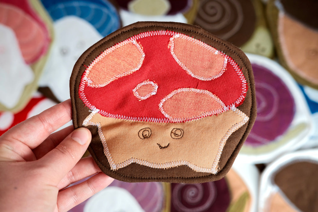 Forest Friend Chantal the Mushroom Coaster, Red and Beige on Brown Background